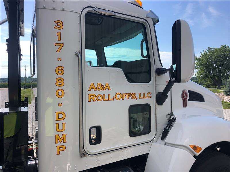 A white dump truck is parked on the side of the road.
