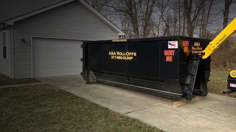 A dumpster is parked in front of a house.