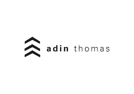 A black and white logo for a company called adina thomas.