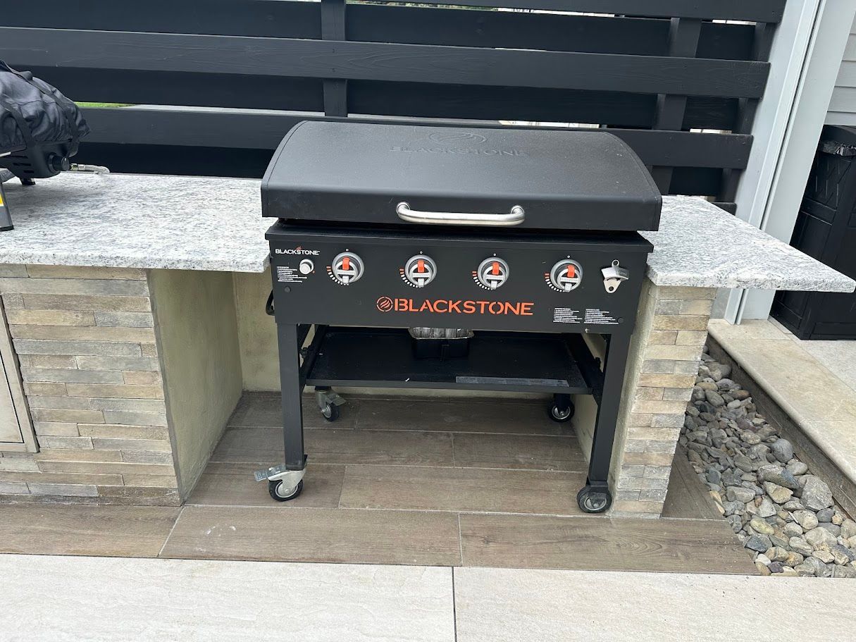 Blackstone griddle with closed lid on a granite countertop.