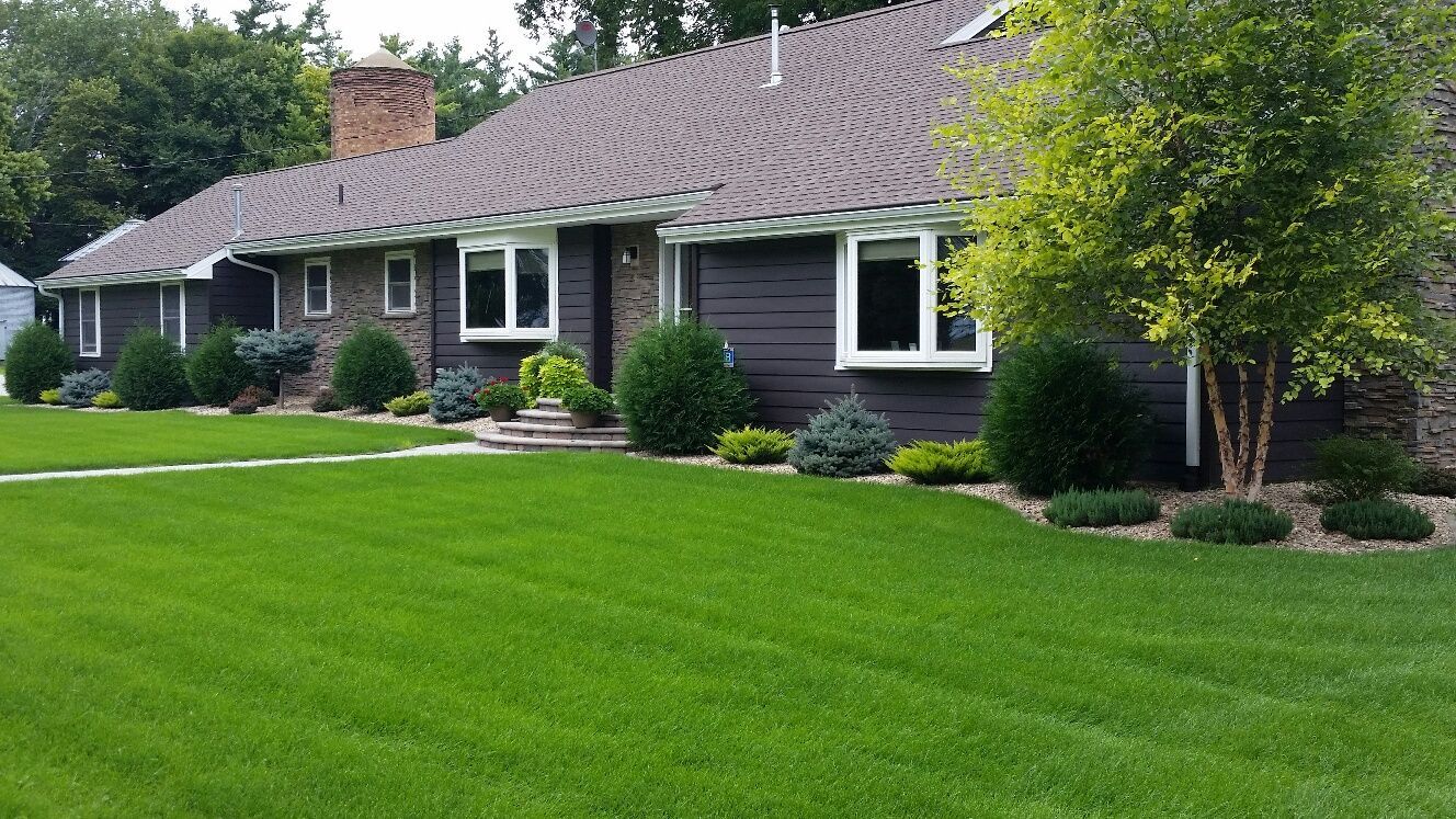 A large house with a lush green lawn in front of it.