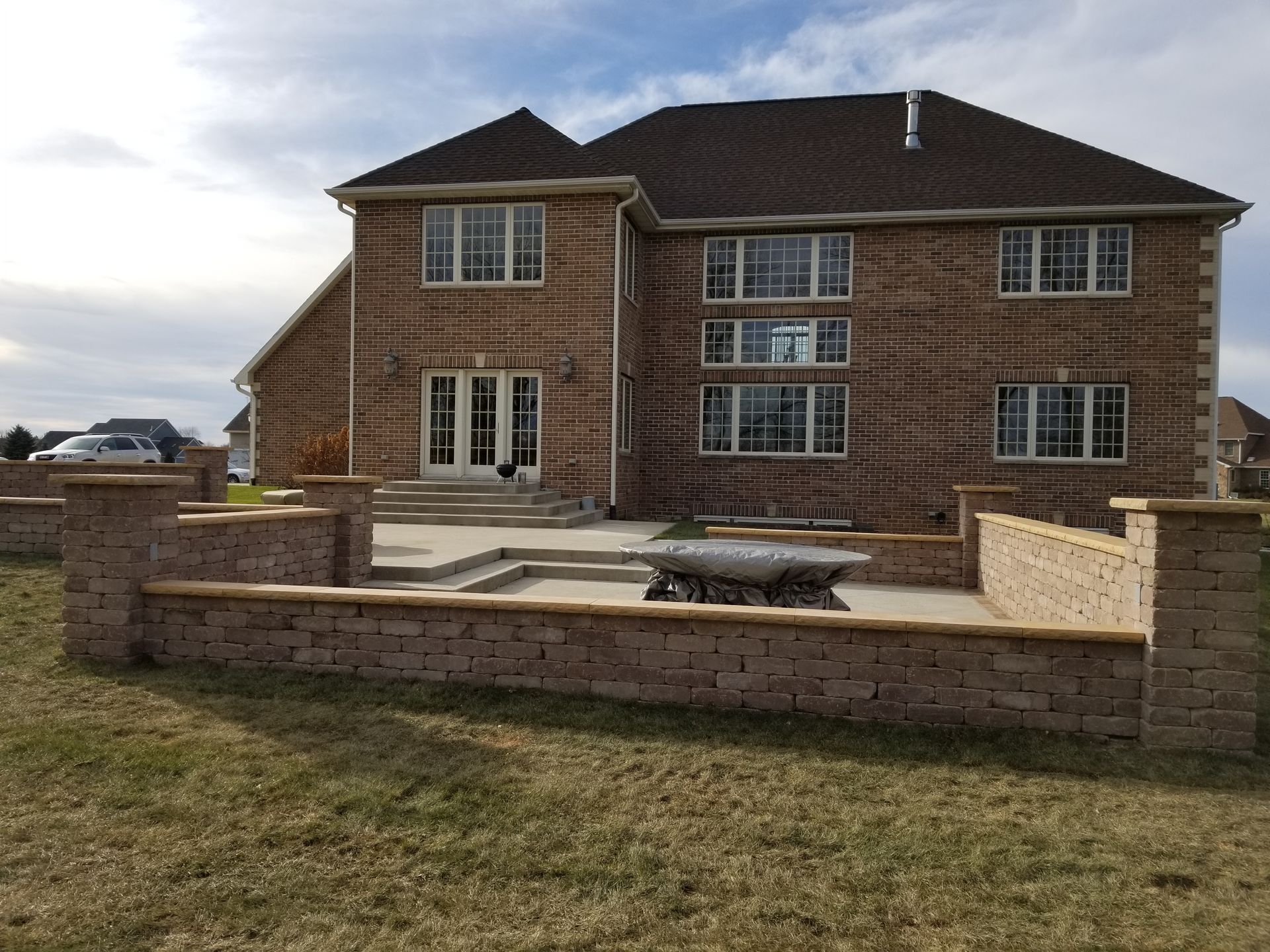 A large brick house with a brick wall in front of it