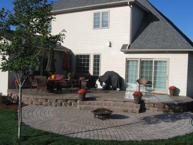 A house with a patio and a fire pit in front of it