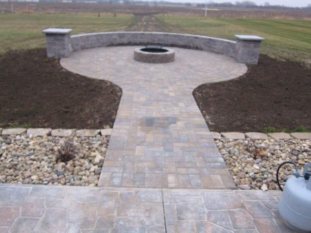 A walkway leading to a fire pit in the middle of a field