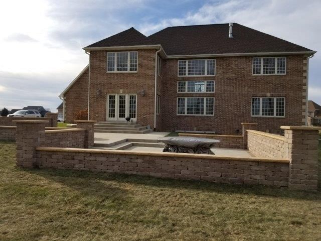 A large brick house with a brick wall in front of it
