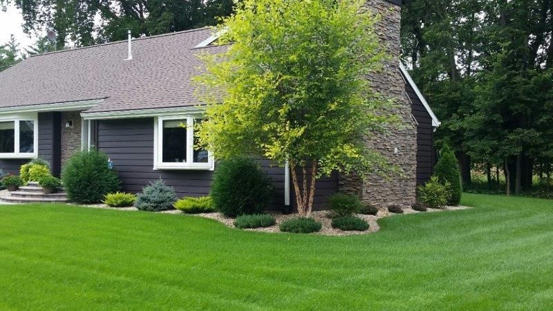 A house with a lush green lawn in front of it.
