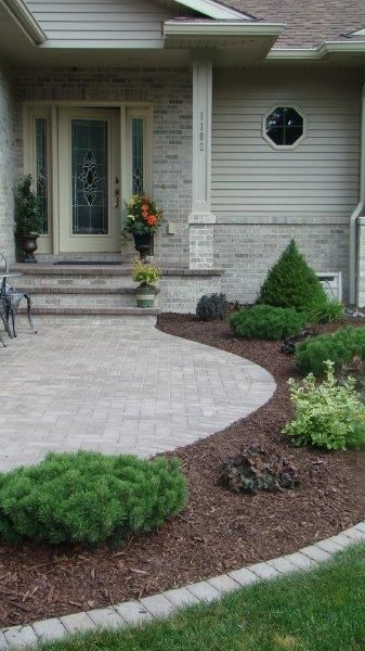 A house with a brick walkway leading to the front door.