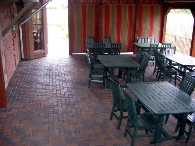 A patio with tables and chairs and a striped awning