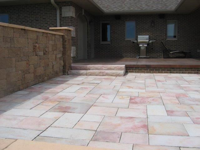A brick house with a patio and stairs leading to it