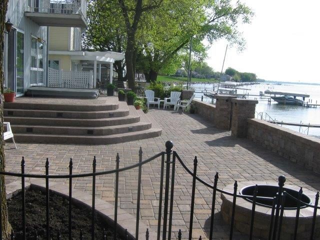 A patio with stairs and a fire pit in front of a house