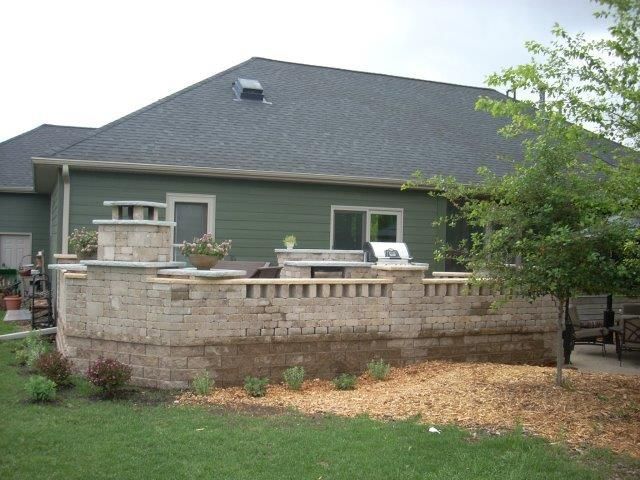 A house with a brick wall in front of it