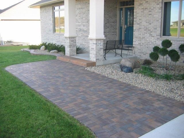 A brick walkway leading to the front door of a house.