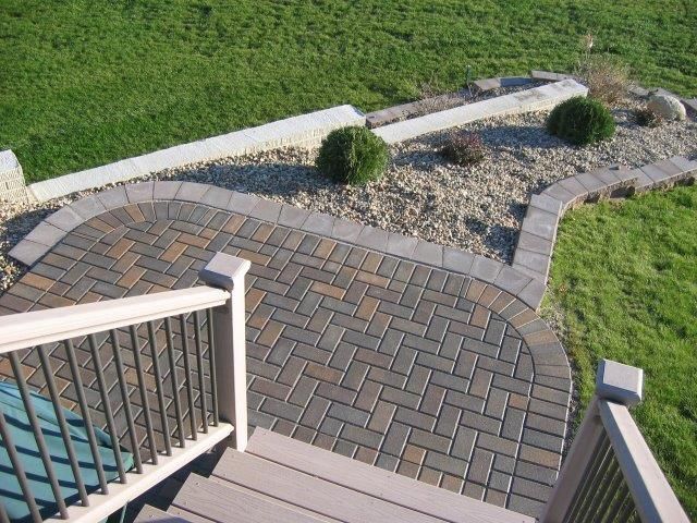 A deck with a brick walkway leading to it