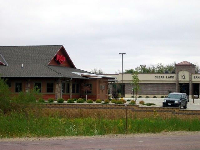 A car is parked in front of a building that says clear lake