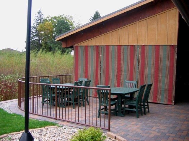A patio with a table and chairs behind a fence