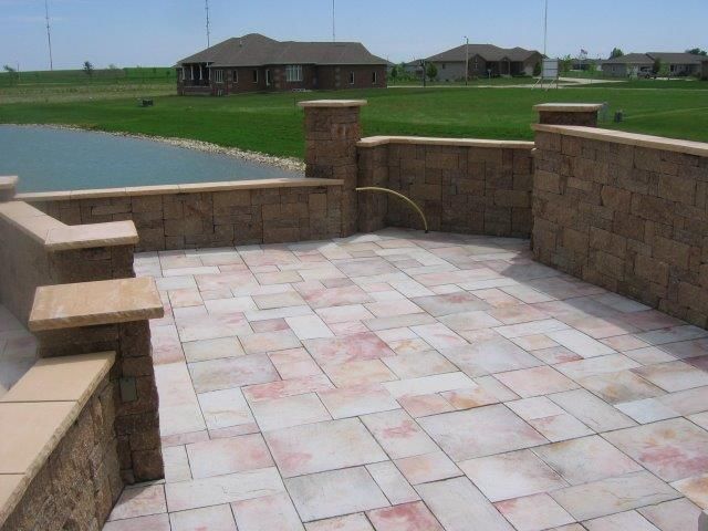 A brick patio with a house in the background