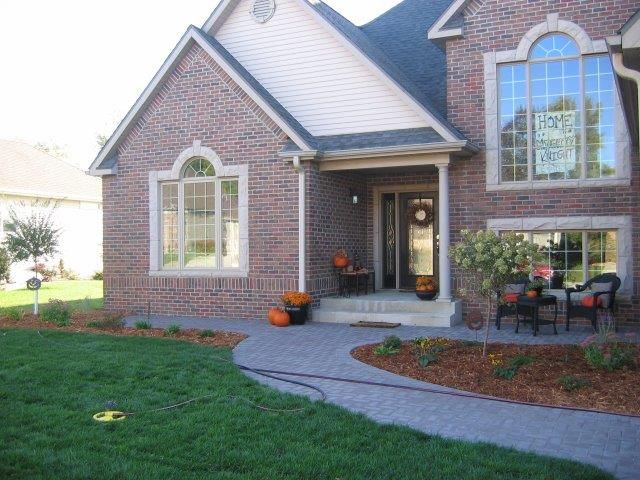 A large brick house with a sign on the front door that says 