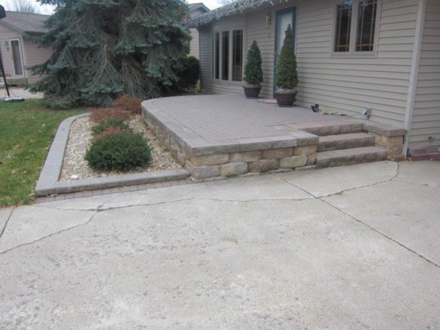 A house with a patio and stairs in front of it.