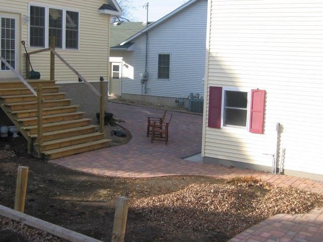 A white house with red shutters sits next to a yellow house