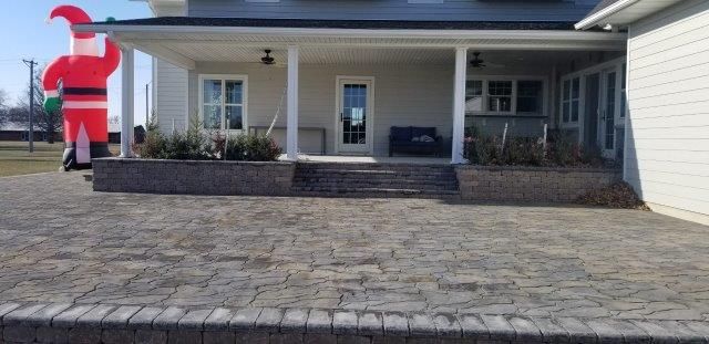 A large inflatable santa claus is sitting on the porch of a house.