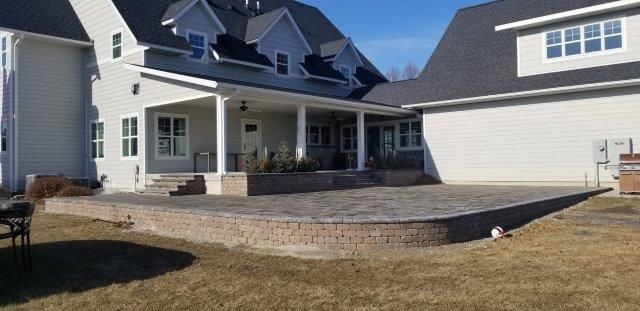 A large white house with a large patio in front of it.