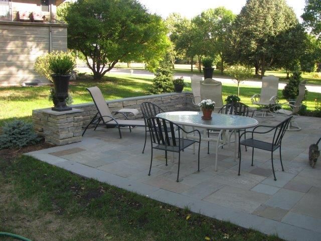 A patio with a table and chairs and a cat