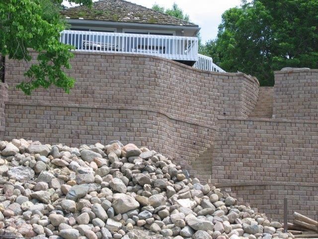 A large pile of rocks in front of a brick wall