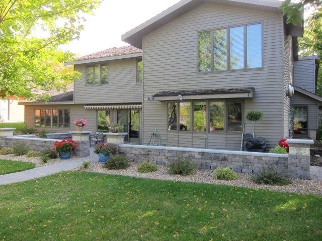 A large house with a lot of windows and a large lawn in front of it