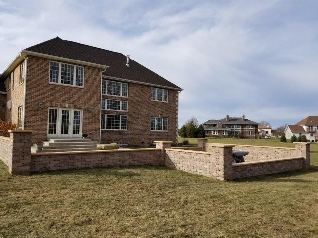 A large brick house with a brick wall in front of it