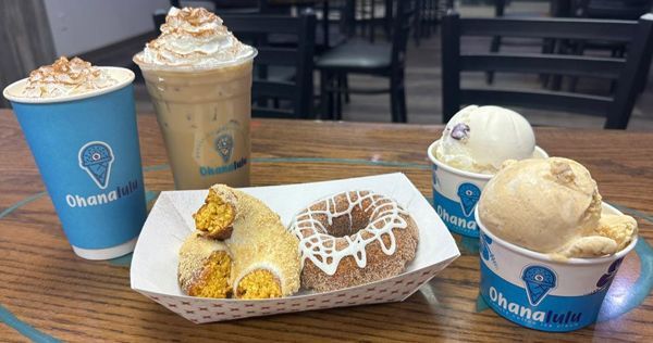 A table topped with ice cream, donuts, and drinks.