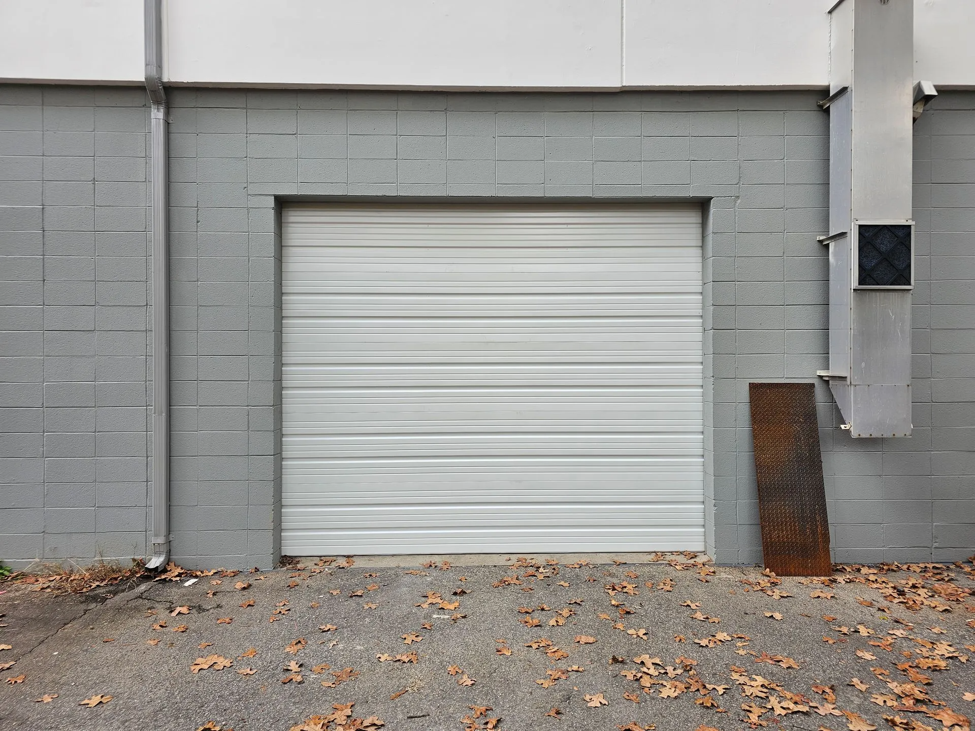 A white garage door is on the side of a building