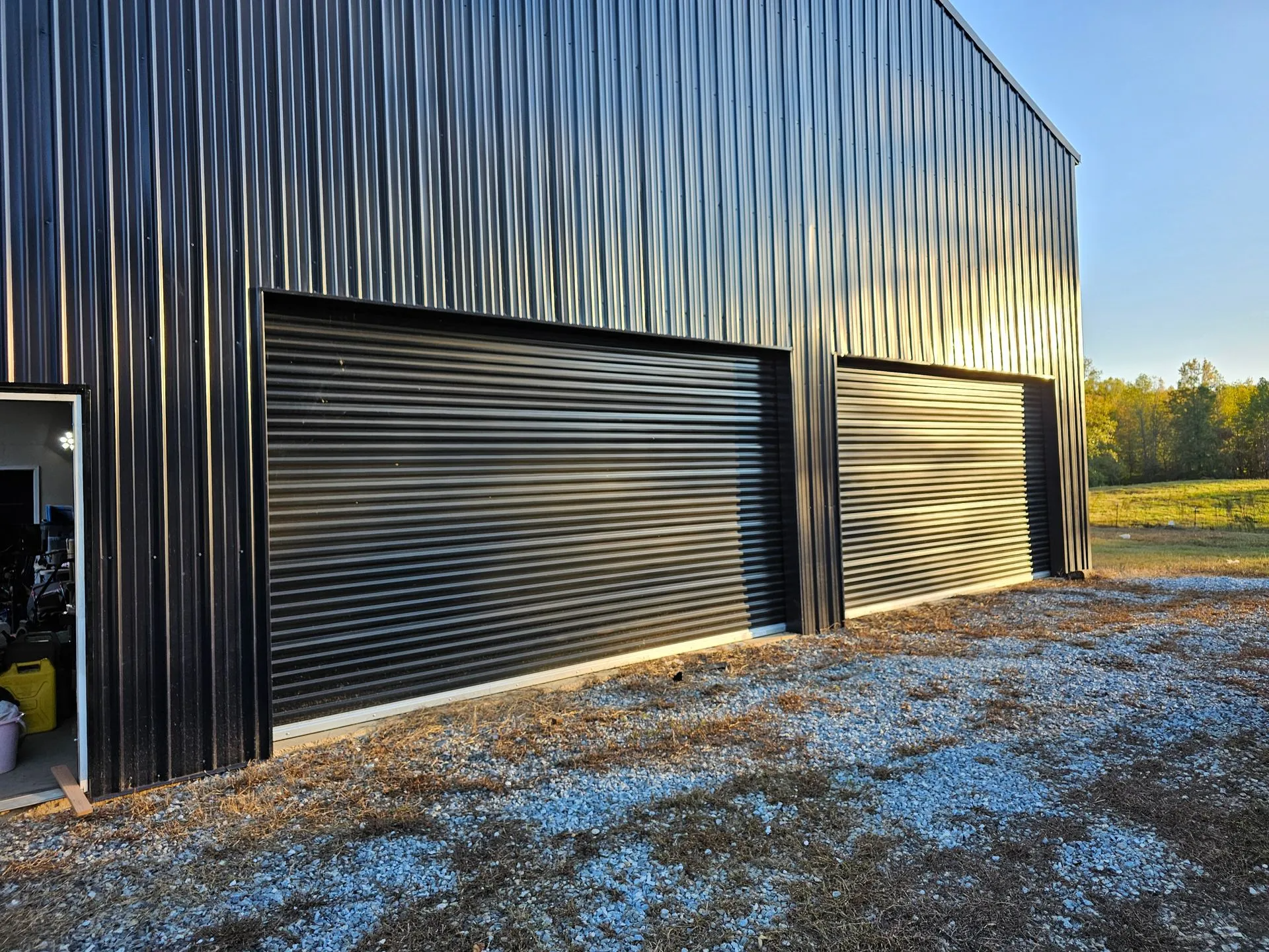There are two garage doors on the side of a building.