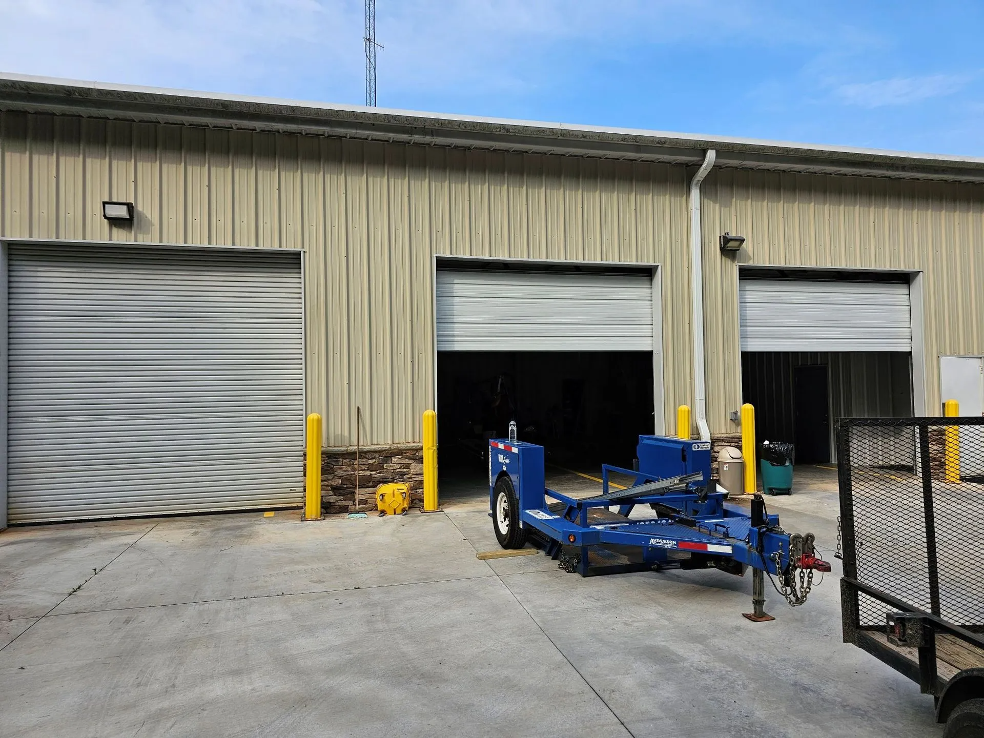 A blue trailer is parked in front of a building.