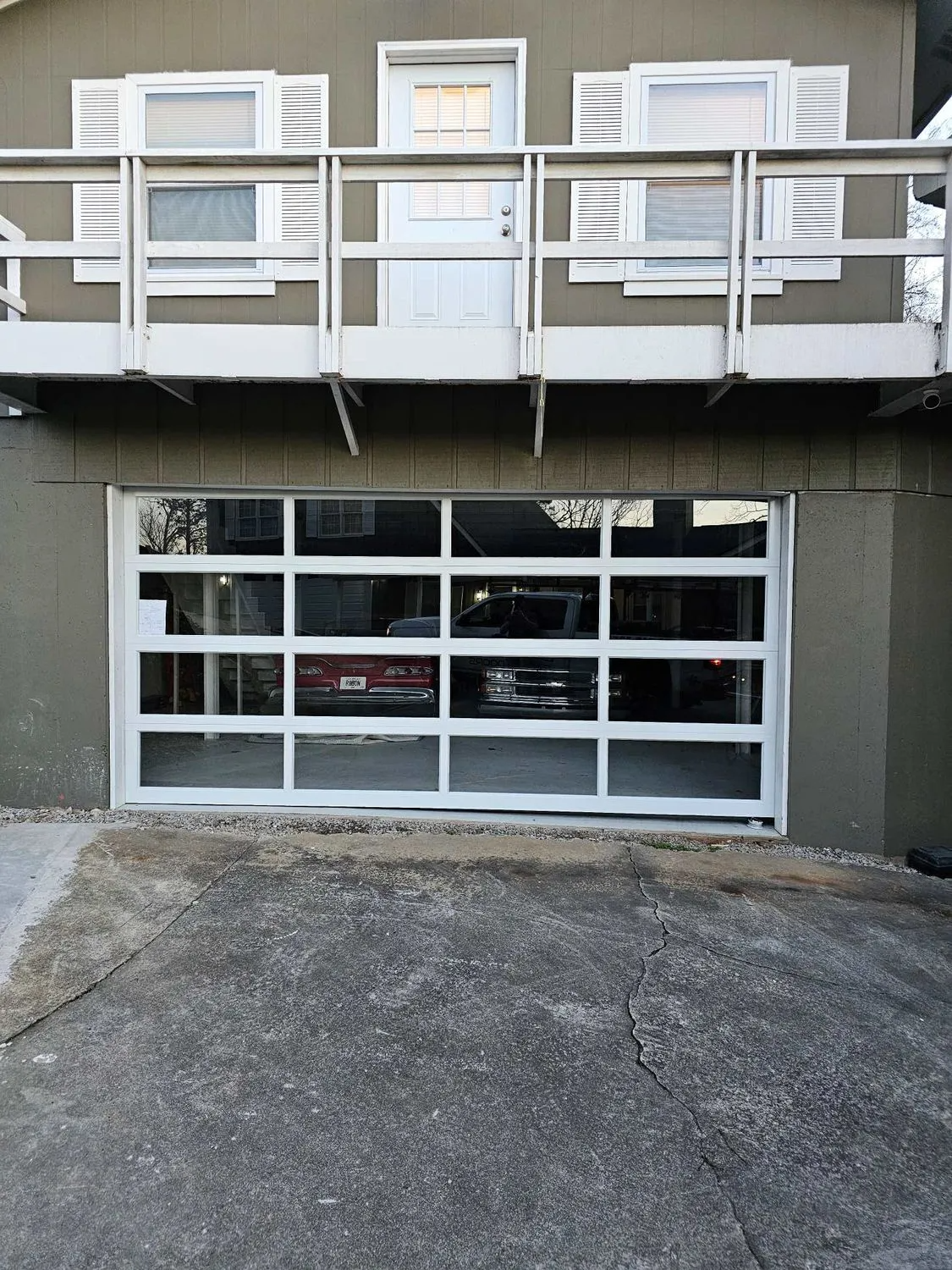 A garage door with a lot of windows and a balcony above it.