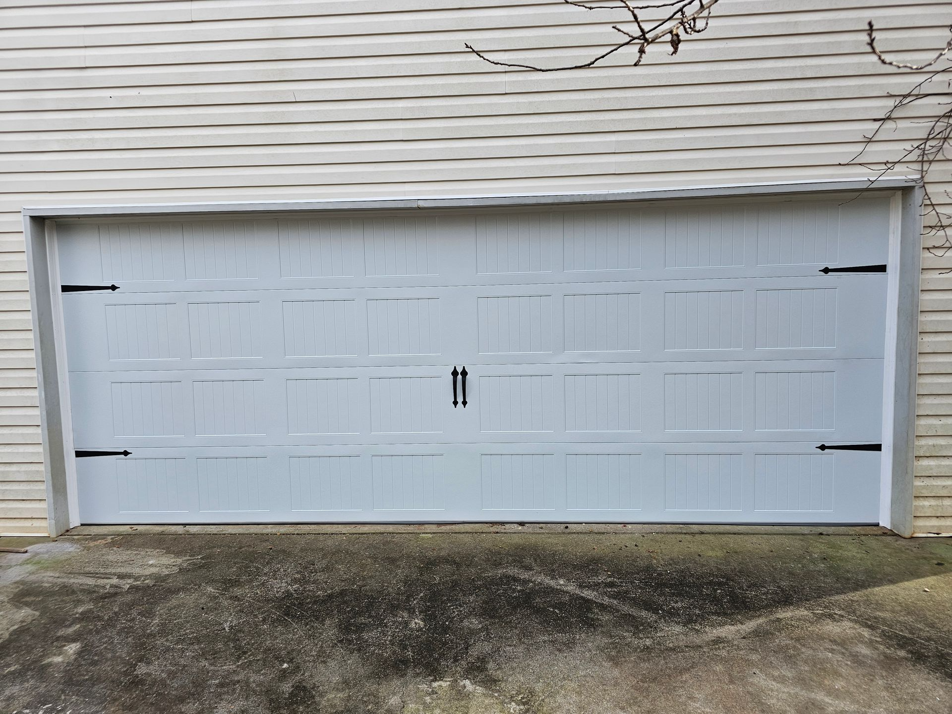 A white garage door is sitting on the side of a house.