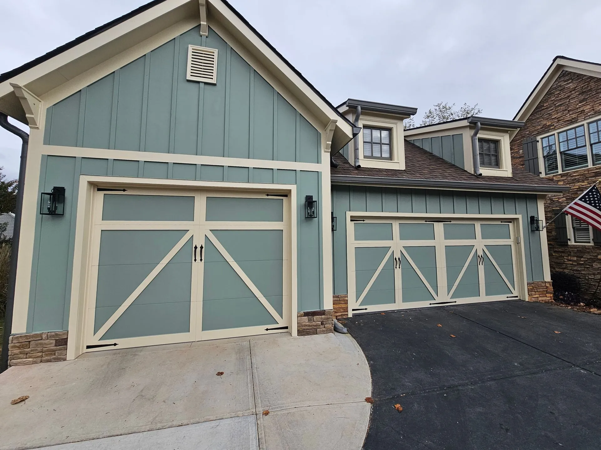A house with two garage doors and an american flag