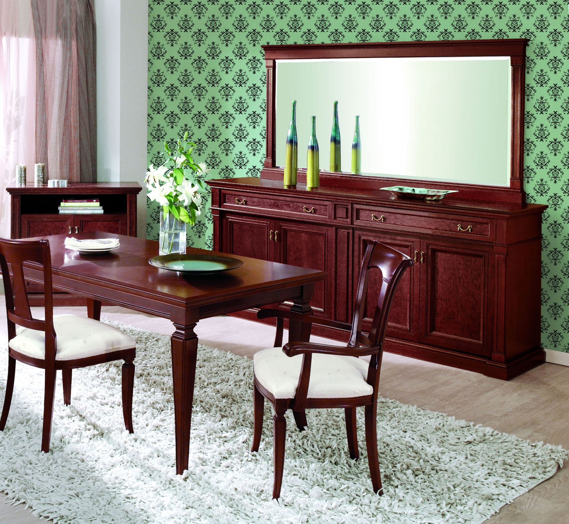 A hand uses a metal scraper to peel off layers of light-colored wallpaper from a wall.