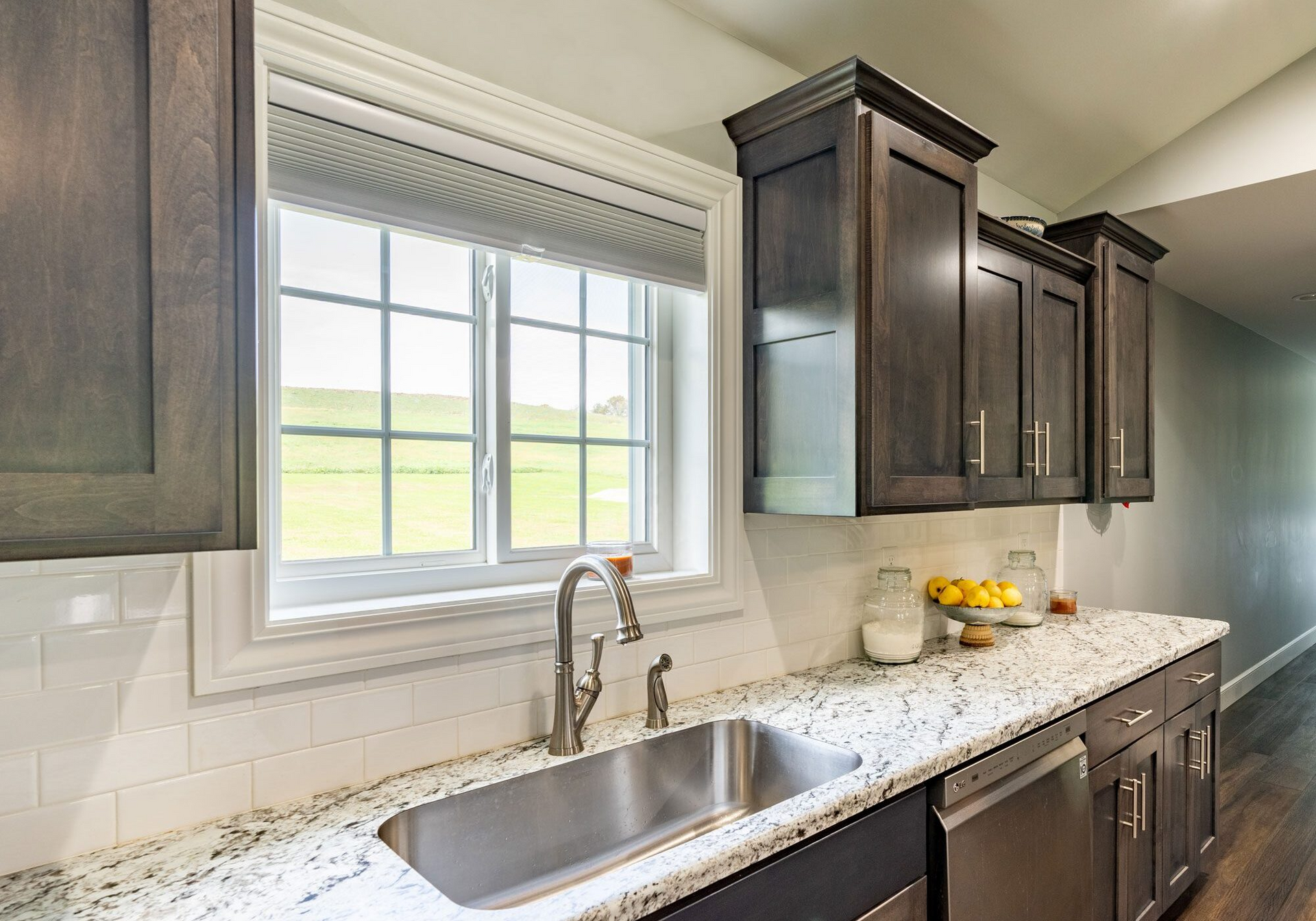 A kitchen with a sink , cabinets , and a window.