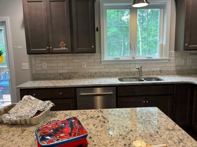 A kitchen with a spiderman lunch box on the counter.