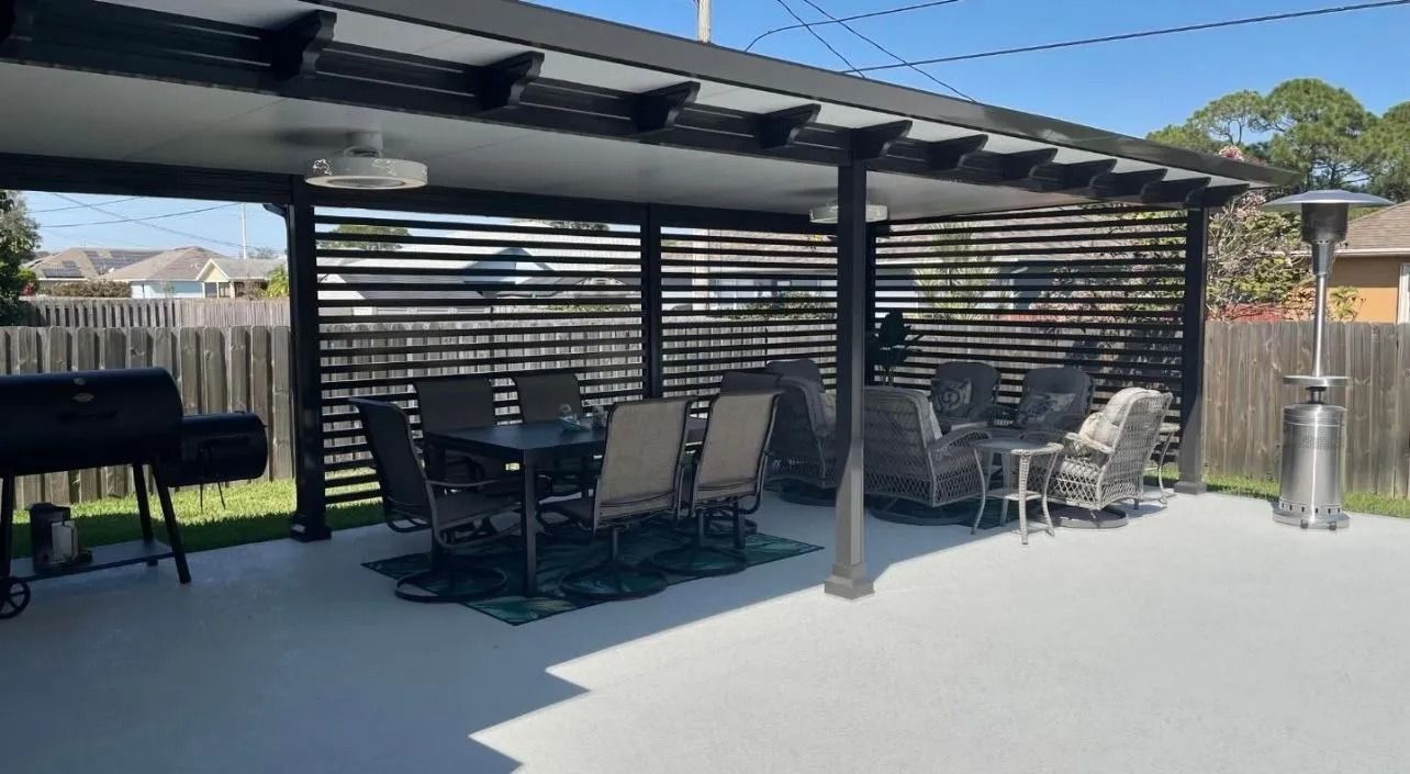 Outdoor patio with pergola, seating, grill, and heater on a sunny day.