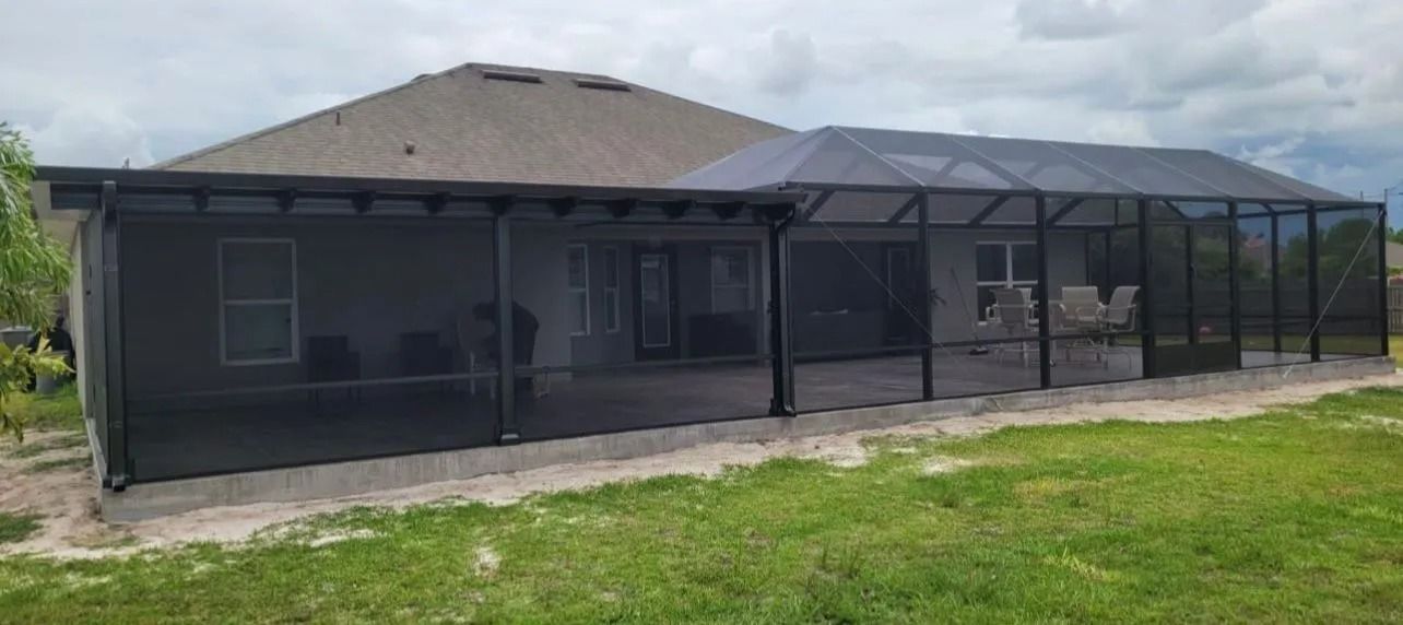 Backyard screen enclosure attached to a house with a concrete patio.