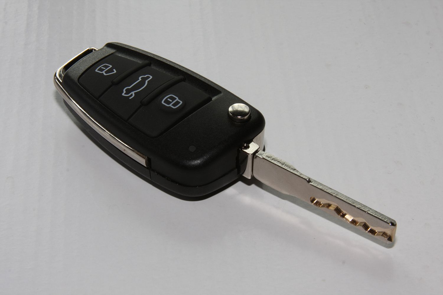 A close up of a car key on a white surface