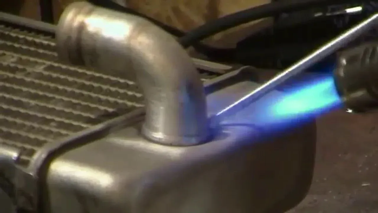A person is welding a piece of metal with a torch.