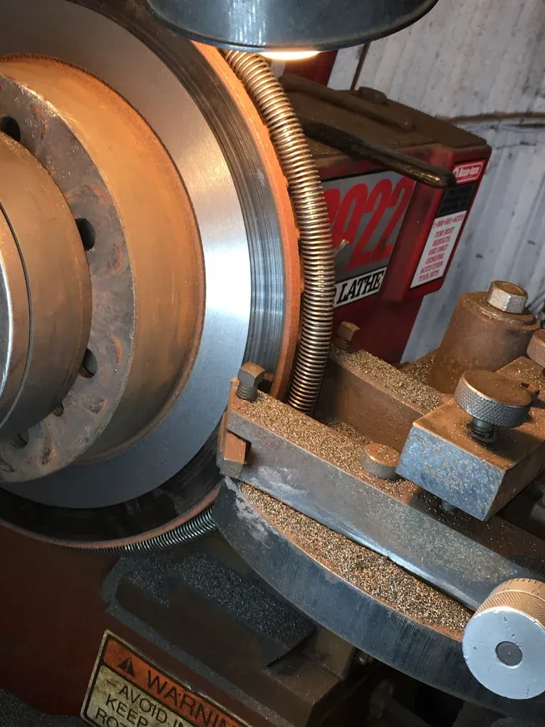 A close up of a machine cutting a brake disc.
