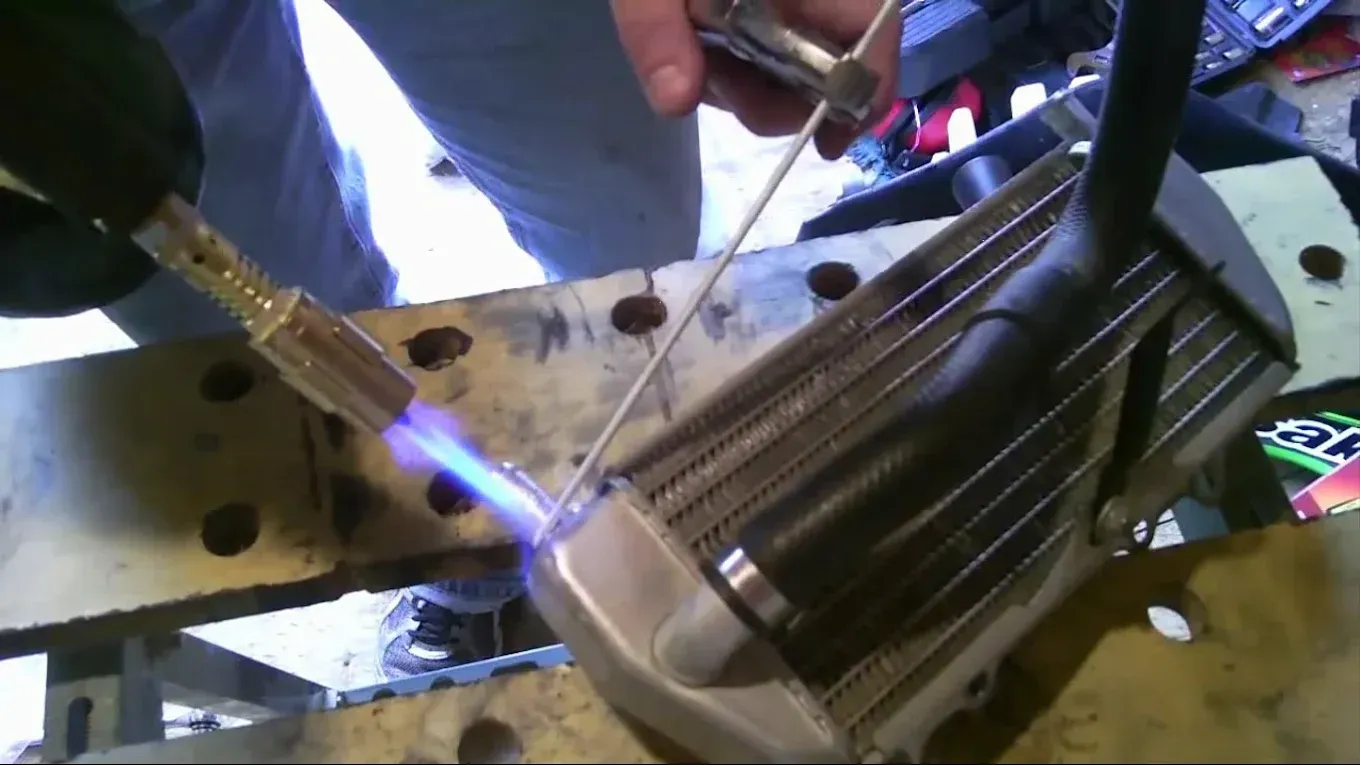 A person is welding a piece of metal with a torch.