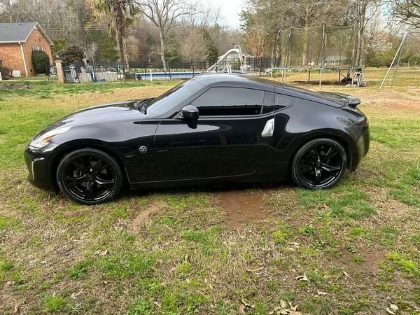 A black sports car is parked in a grassy field.