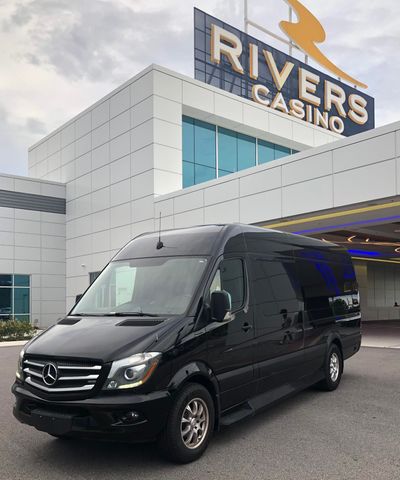Black van parked in front of Rivers Casino. Building is white with blue windows and a sign.