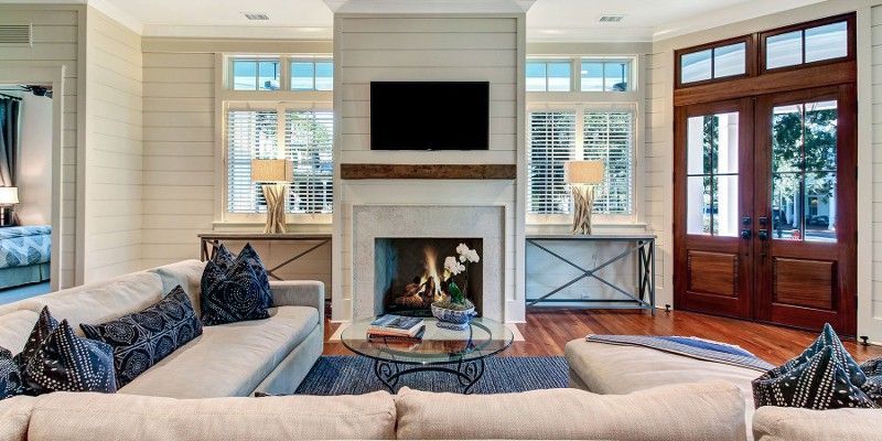 A living room with a couch , fireplace and television.