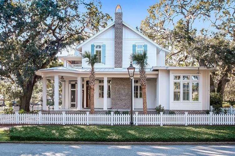 A white house with a white picket fence around it