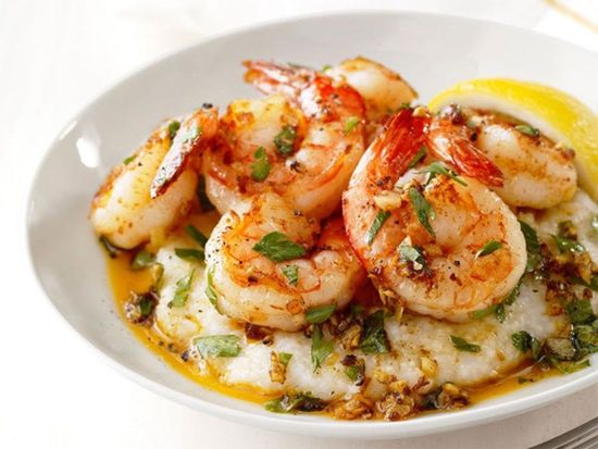 Shrimp scampi with herbs and lemon on a white plate